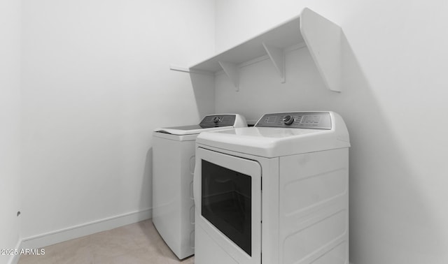 laundry room featuring laundry area, baseboards, and separate washer and dryer