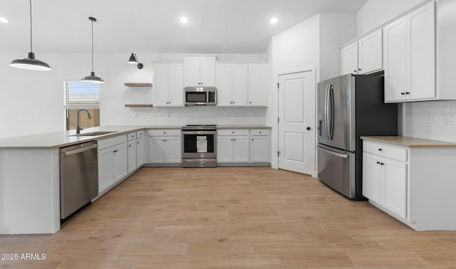 kitchen featuring a sink, white cabinetry, open shelves, decorative backsplash, and stainless steel appliances