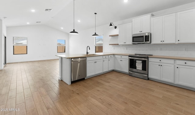 kitchen featuring a sink, open shelves, visible vents, appliances with stainless steel finishes, and tasteful backsplash