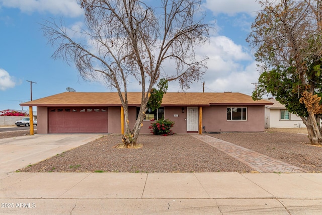 ranch-style house with an attached garage, concrete driveway, and stucco siding