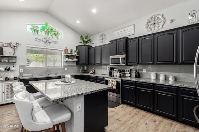 3545 W Tanner Ranch Rd, San Tan Valley, AZ 85144 - kitchen featuring stainless steel appliances, a sink, a breakfast bar, decorative backsplash, and a kitchen island