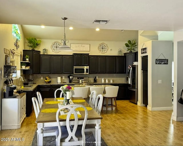 3545 W Tanner Ranch Rd, San Tan Valley, AZ 85144 - kitchen with stainless steel appliances, backsplash, a center island, and light wood finished floors