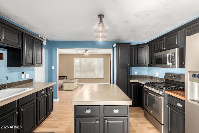 8331 N 6th St, Phoenix, AZ 85020 - kitchen with appliances with stainless steel finishes, a kitchen island, light wood finished floors, and light countertops
