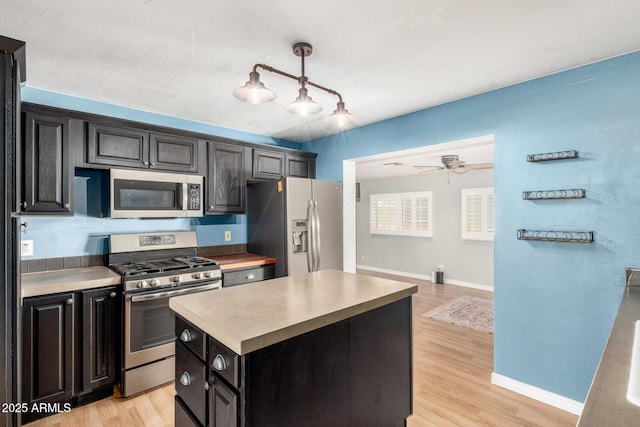 8331 N 6th St, Phoenix, AZ 85020 - kitchen with stainless steel appliances, light wood-style floors, a center island, light countertops, and dark cabinetry