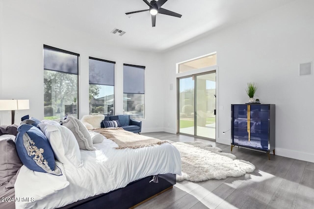 bedroom featuring multiple windows, ceiling fan, hardwood / wood-style floors, and access to exterior