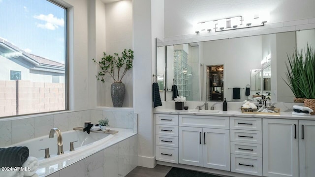 bathroom with tiled bath and vanity