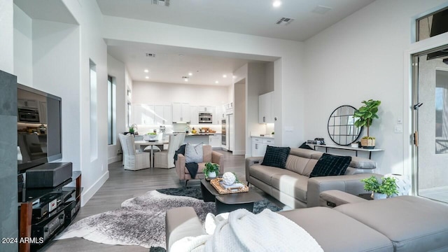 living room with hardwood / wood-style floors and a towering ceiling