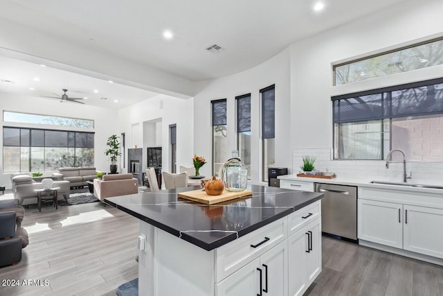 kitchen with dishwasher, white cabinets, a healthy amount of sunlight, and a kitchen island