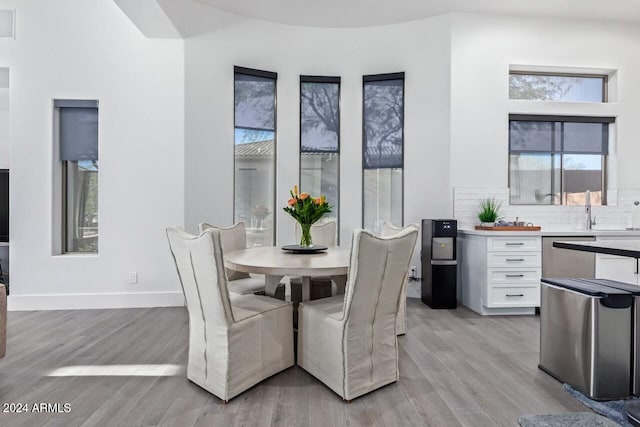 dining space with light hardwood / wood-style floors and sink