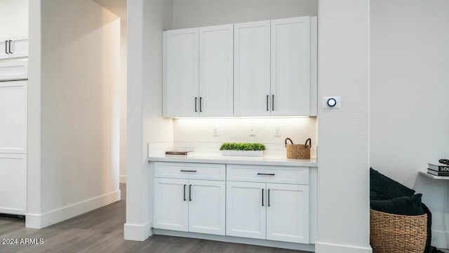 bar with white cabinetry and light hardwood / wood-style floors