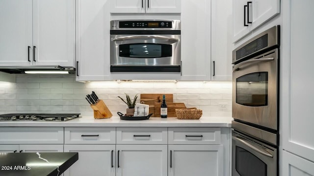 kitchen featuring backsplash, white cabinets, and stainless steel appliances