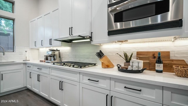 kitchen featuring appliances with stainless steel finishes, tasteful backsplash, white cabinetry, and sink