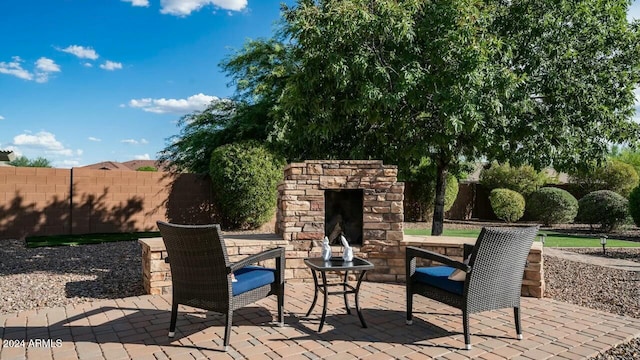 view of patio featuring an outdoor stone fireplace