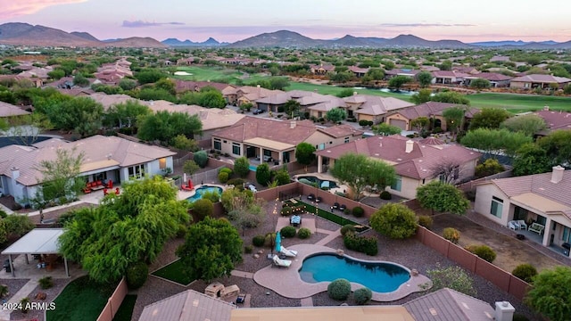 aerial view at dusk featuring a mountain view