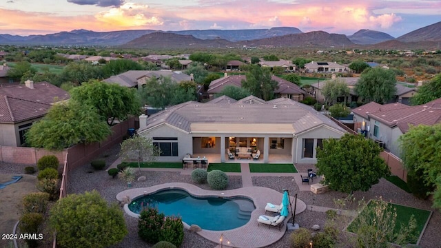 pool at dusk featuring a patio area and a mountain view