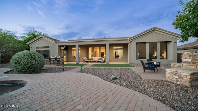 rear view of property featuring an outdoor hangout area, a pool, and a patio area