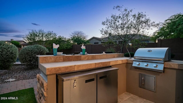 patio terrace at dusk featuring area for grilling and grilling area