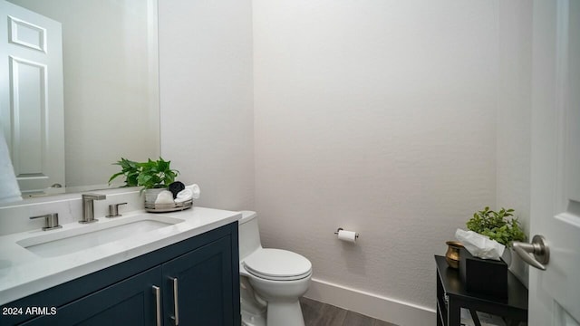 bathroom with hardwood / wood-style flooring, vanity, and toilet