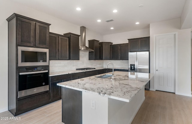 22523 E Orchard Ln, Queen Creek, AZ 85142 - kitchen featuring stainless steel appliances, a sink, wall chimney range hood, light wood-style flooring, and tasteful backsplash