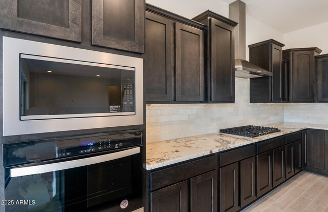 22523 E Orchard Ln, Queen Creek, AZ 85142 - kitchen with appliances with stainless steel finishes, wall chimney exhaust hood, backsplash, light stone counters, and dark brown cabinets