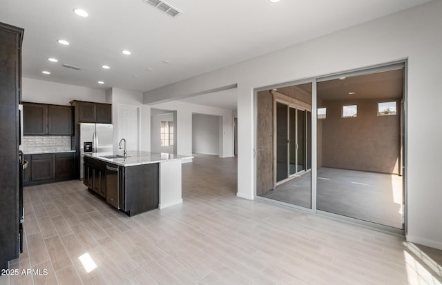 22523 E Orchard Ln, Queen Creek, AZ 85142 - kitchen with dark brown cabinets, recessed lighting, a sink, backsplash, and an island with sink