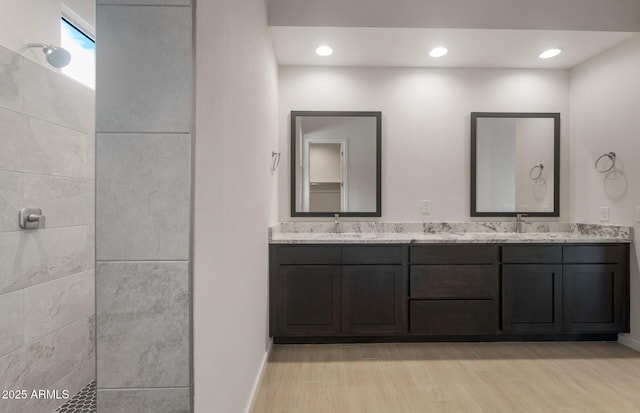 22523 E Orchard Ln, Queen Creek, AZ 85142 - bathroom featuring walk in shower, double vanity, wood finished floors, and baseboards