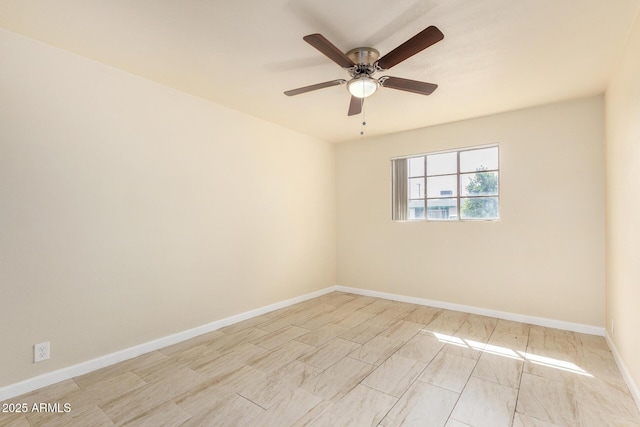 unfurnished room with a ceiling fan and baseboards