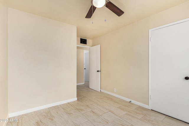 empty room with visible vents, a ceiling fan, and baseboards