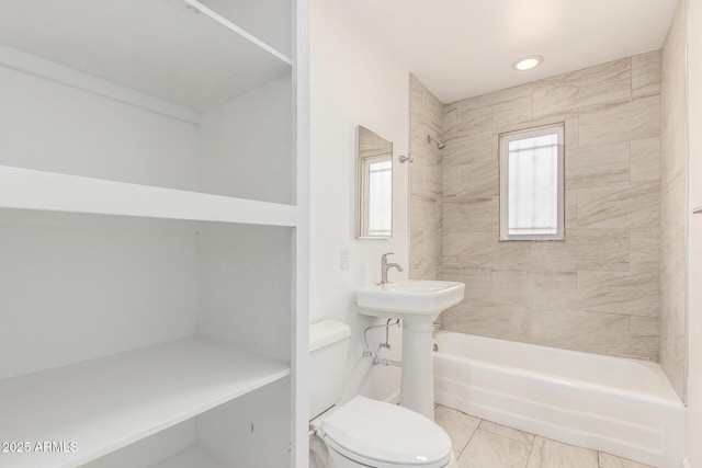 full bathroom featuring toilet, a healthy amount of sunlight, and shower / washtub combination