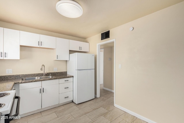 kitchen with a sink, visible vents, white appliances, and white cabinetry