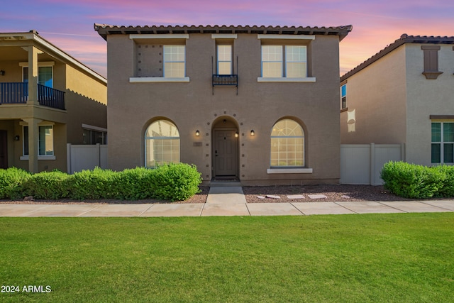 mediterranean / spanish-style home featuring a lawn and a balcony