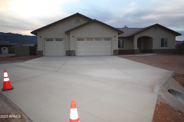 ranch-style home with a garage and a mountain view