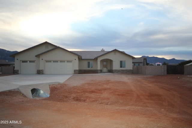 single story home with a garage and a mountain view