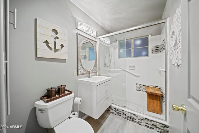 bathroom with vanity, hardwood / wood-style floors, toilet, and a shower with door