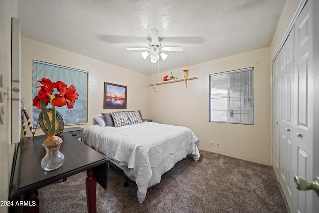 bedroom with a textured ceiling, carpet, ceiling fan, and a closet