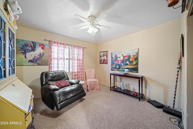 living area featuring a textured ceiling, carpet flooring, and ceiling fan