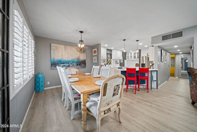 dining space featuring a notable chandelier and light hardwood / wood-style flooring