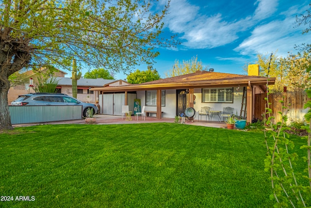 back of house featuring a garage and a yard