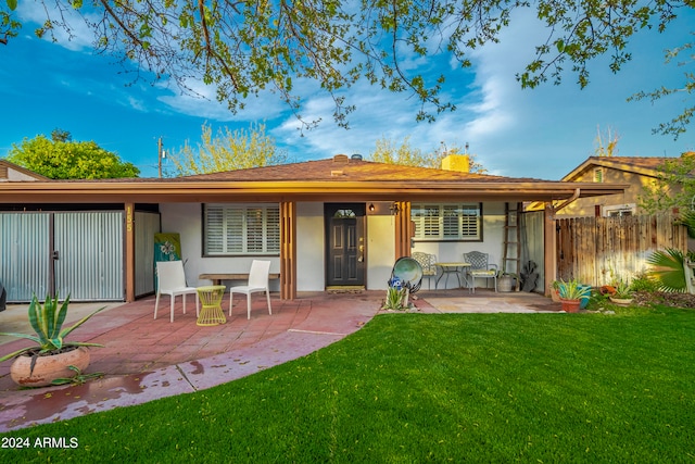 back of property with a patio and a yard