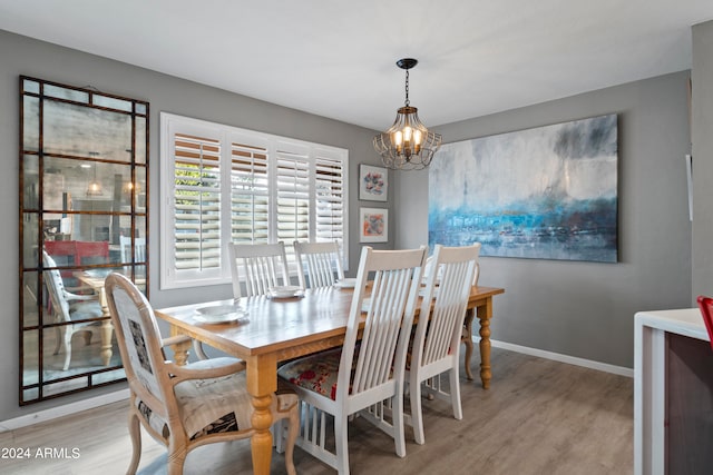 dining area with an inviting chandelier and light hardwood / wood-style flooring