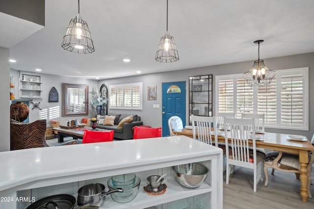 kitchen with light wood-type flooring, a chandelier, and decorative light fixtures