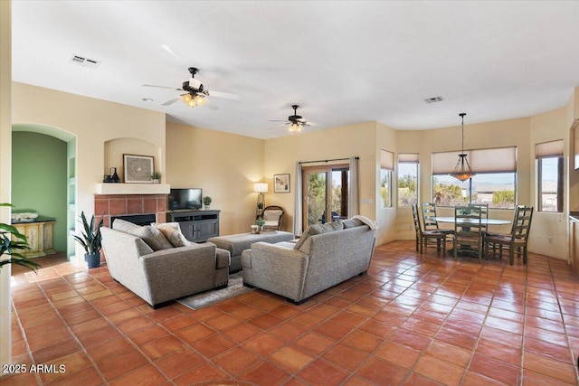 28607 N 152nd St, Scottsdale, AZ 85262 - tiled living room with visible vents, arched walkways, ceiling fan, and a fireplace
