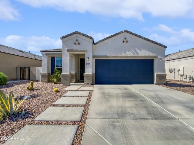 view of front of property featuring a garage, driveway, a tiled roof, and stucco siding