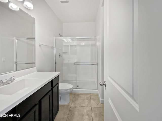 full bathroom featuring vanity, a shower stall, toilet, and tile patterned floors