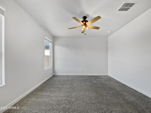 carpeted empty room with a ceiling fan, visible vents, and baseboards