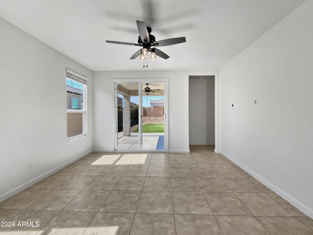 empty room featuring ceiling fan, tile patterned flooring, and baseboards