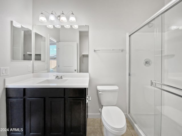 bathroom with a stall shower, vanity, toilet, and tile patterned floors