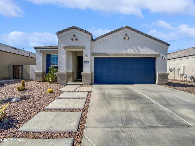 view of front of house with a garage, concrete driveway, a tiled roof, and stucco siding