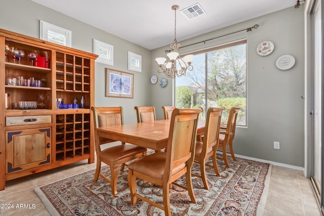 dining room featuring a notable chandelier and light tile flooring