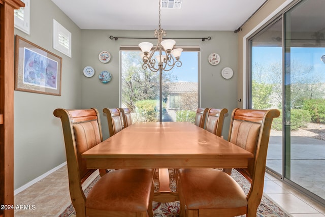 dining room with a chandelier and light tile flooring